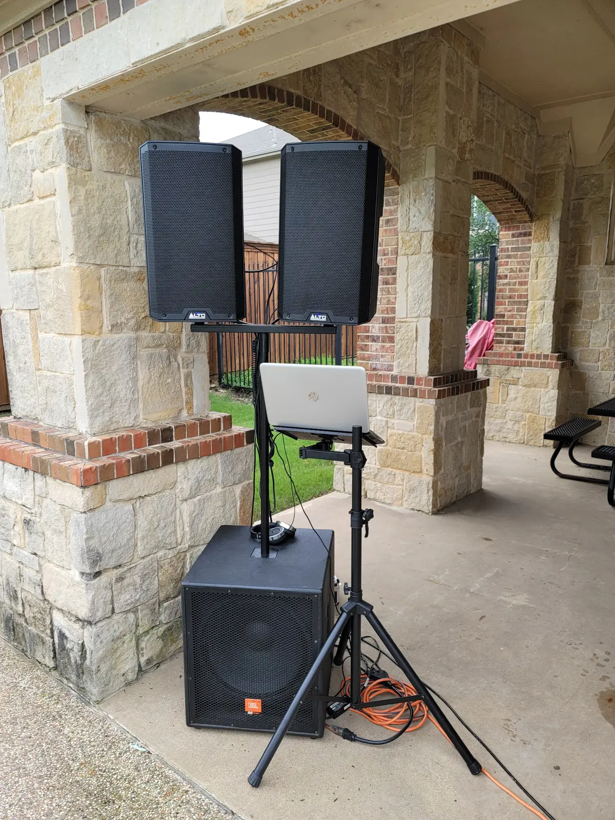 A compact ThatDjGuy sound system arranged beneath a covered stone patio