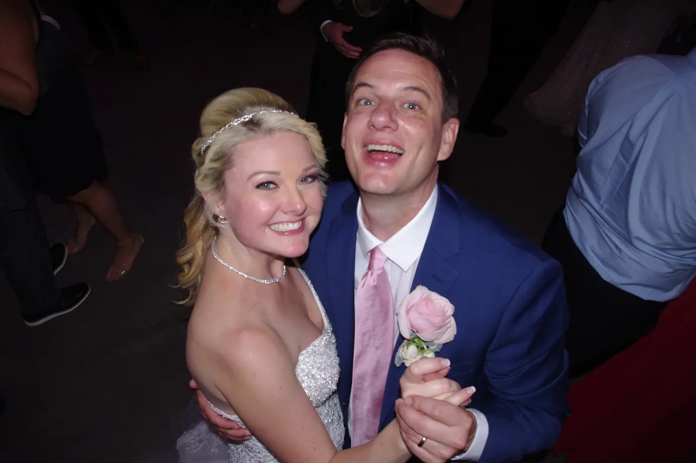 A newlywed couple smiling together on the dance floor