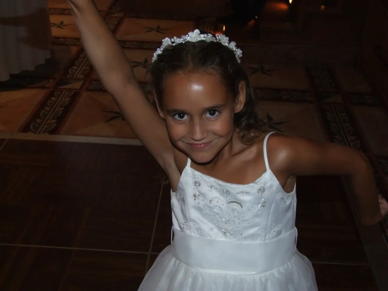 A smiling young wedding guest dancing at the reception